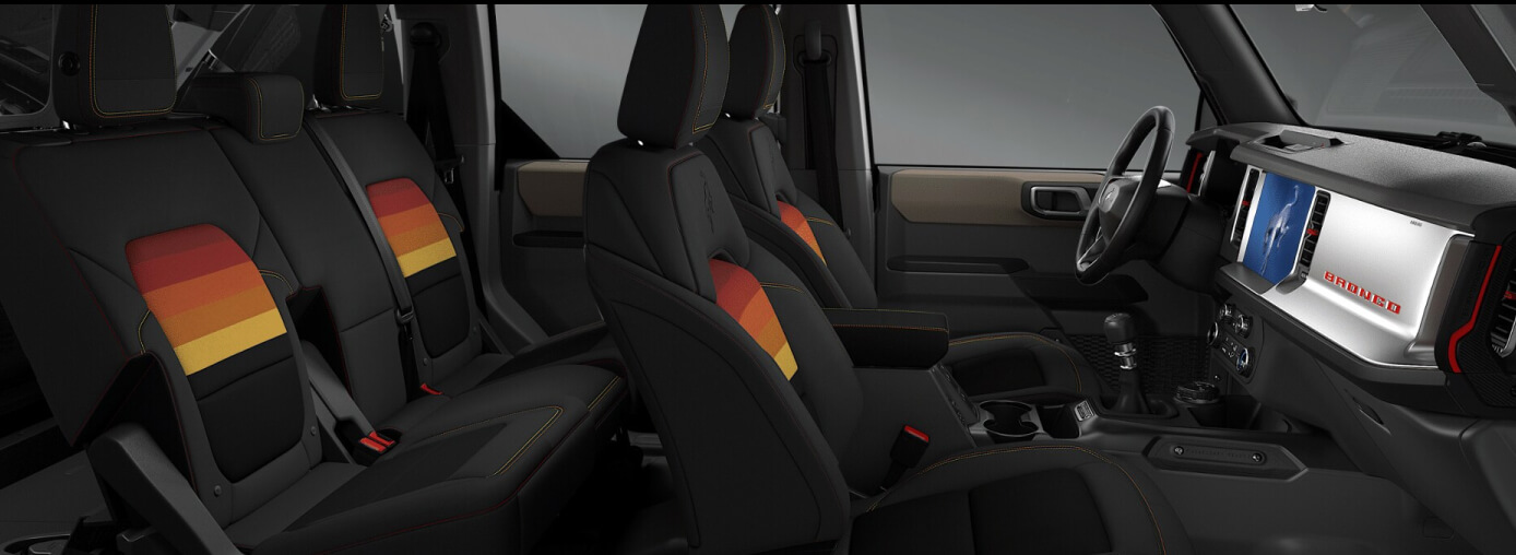 A black Ford Bronco interior with orange and yellow detailing.