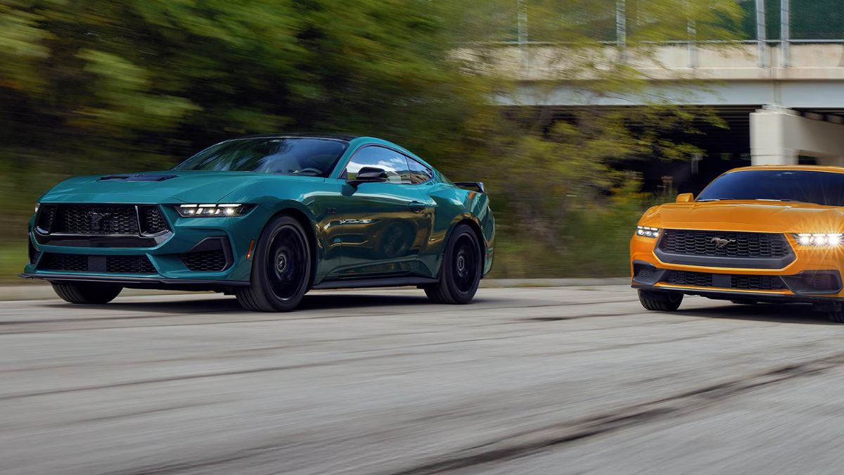Green 2026 Ford Mustang and Orange 2026 Ford Mustang on a Freeway