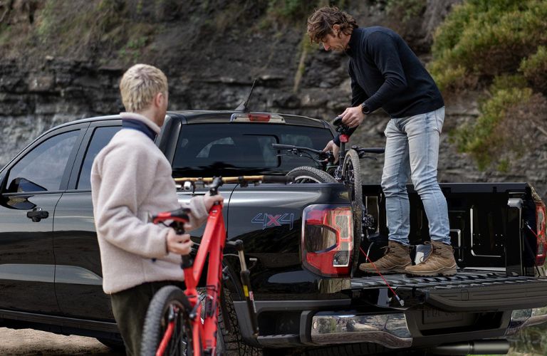 Men Loading Bikes into Rear of Black 2026 Ford Ranger