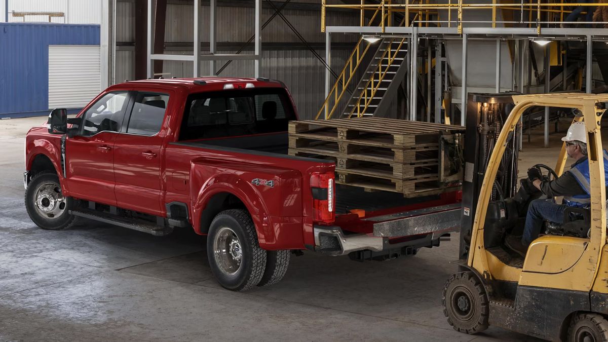 Red 2026 Ford Super Duty® with Forklift Loading Cargo in Back