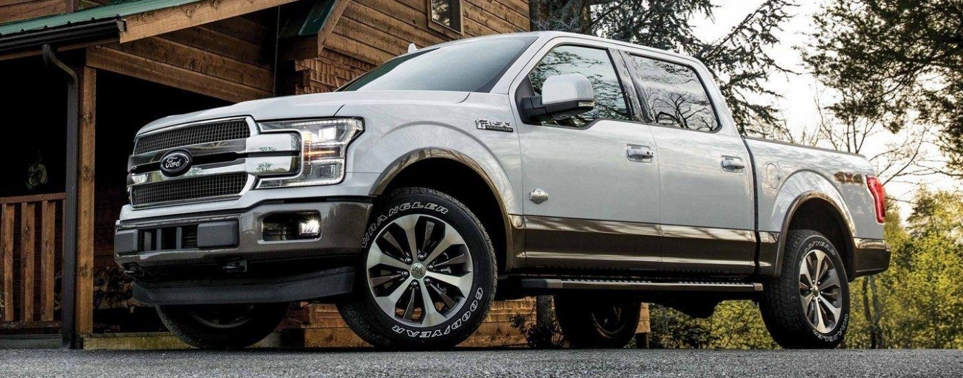 White 2018 Ford F-150 King Ranch parked near a cabin