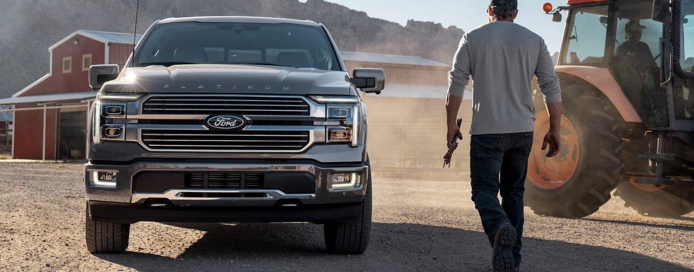 A silver 2025 Ford F-150 Platinum parked in front of a barn.