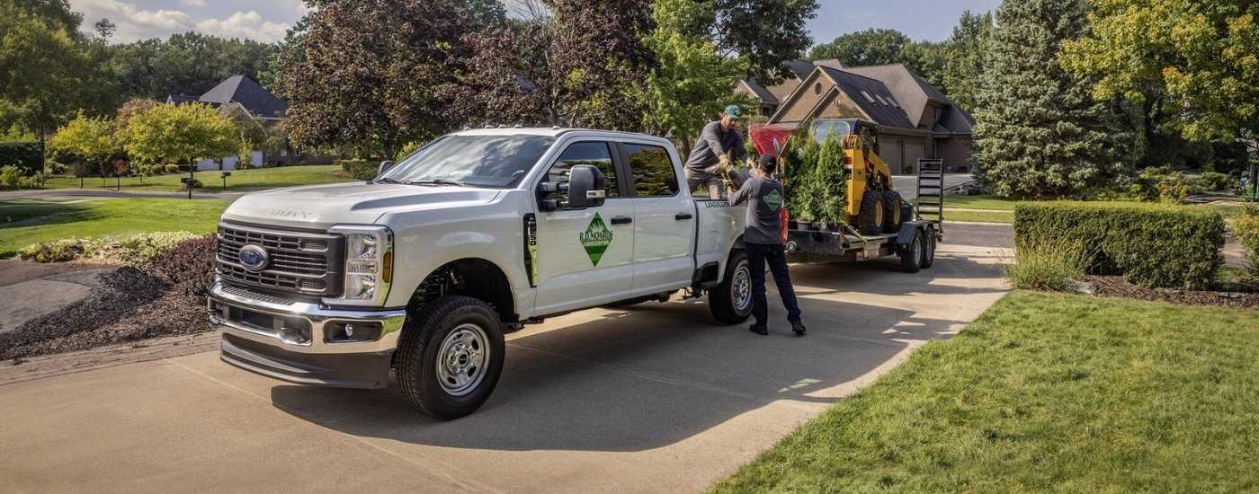 A white 2025 Ford F-250 towing a trailer.