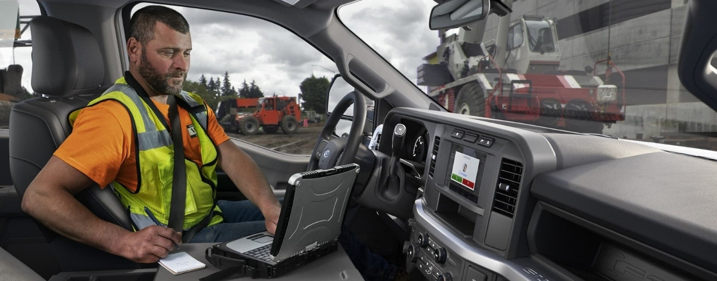 Person using a laptop in a 2025 Ford F-250 XL.