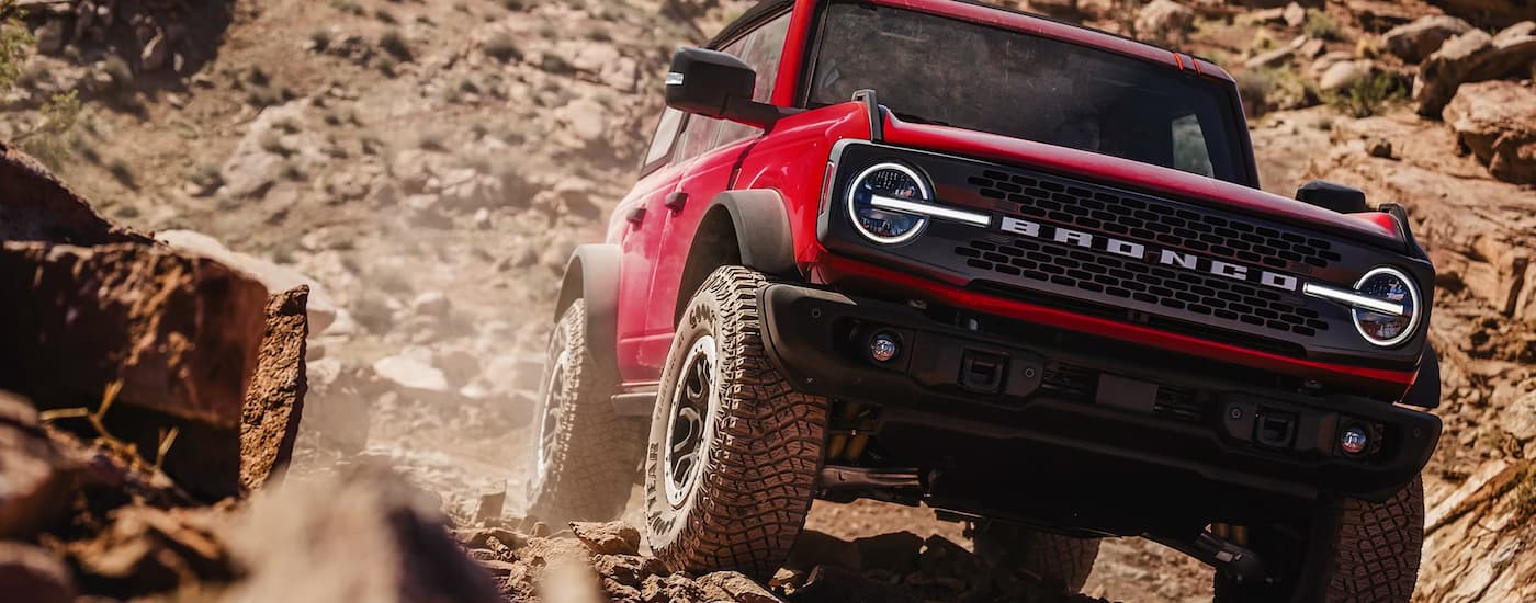 Red 2026 Ford Bronco driving on a dirt trail