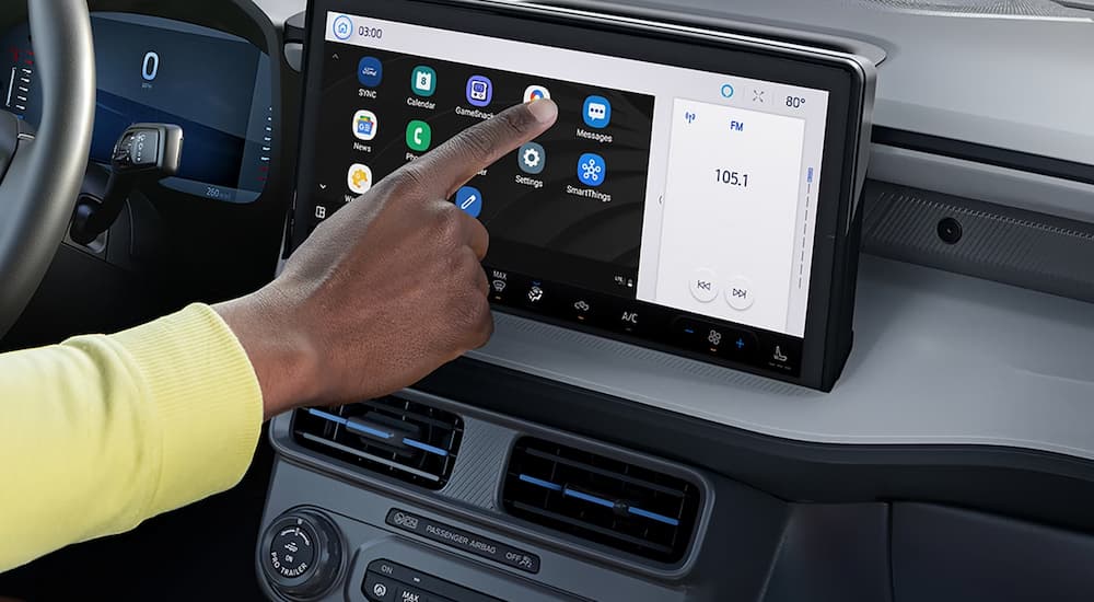 A man using the touchscreen infotainment display in a 2026 Ford Maverick