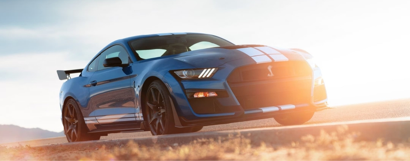 A blue 2022 Ford Mustang GT500 driving on a racetrack.