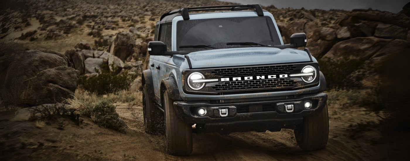A gray 2021 Ford Bronco off-roading on a dirt trail