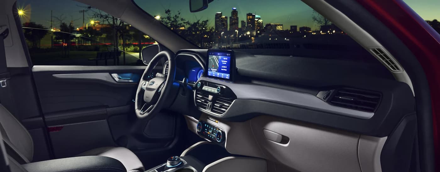 The grey interior of a 2022 Ford Escape shows the steering wheel and infotainment screen.