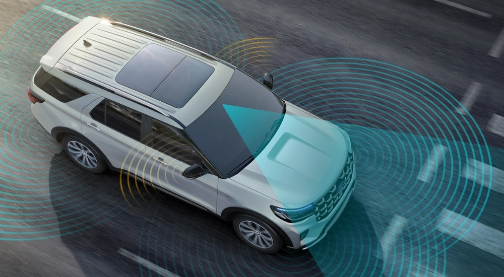A white 2025 Ford Explorer Active with simulated sensor lines.