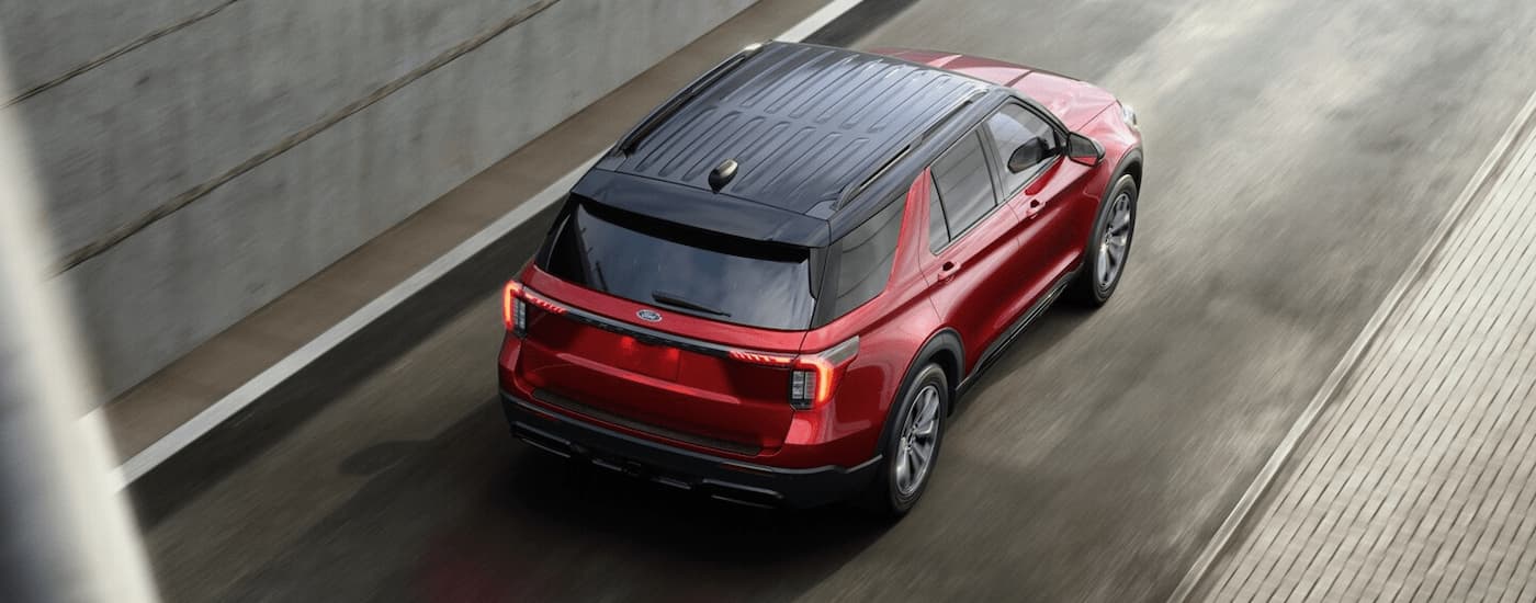 Red 2025 Ford Explorer ST driving on a highway ramp