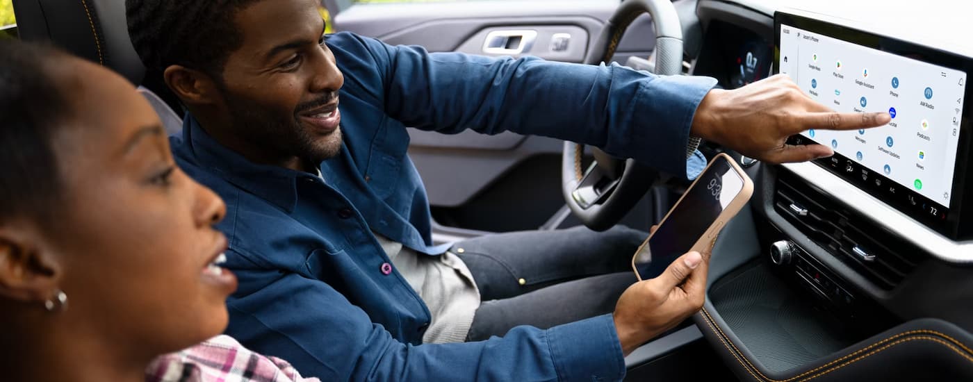 Two people using the infotainment screen in a 2025 Ford Explorer ST