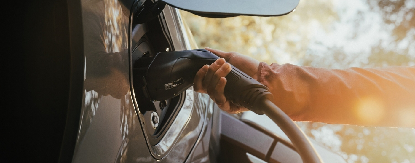A person plugging in a 2025 Ford F-150 Lightning Platinum.