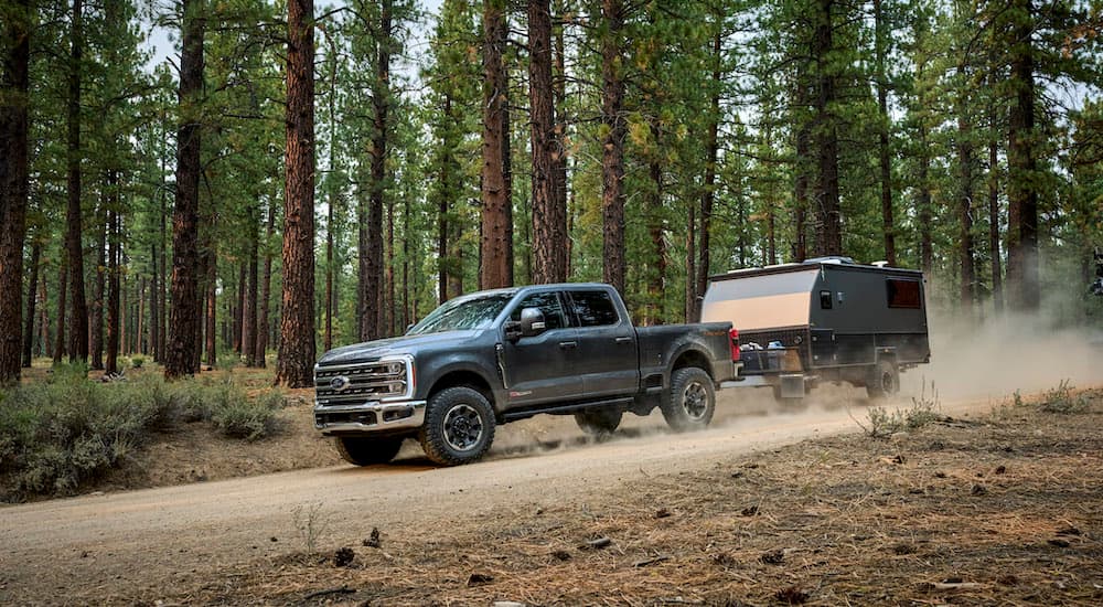 A grey 2025 Ford F-250 from the side while towing a trailer.