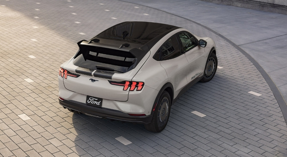 A white 2025 Ford Mustang Mach-E Rally parked in a courtyard.