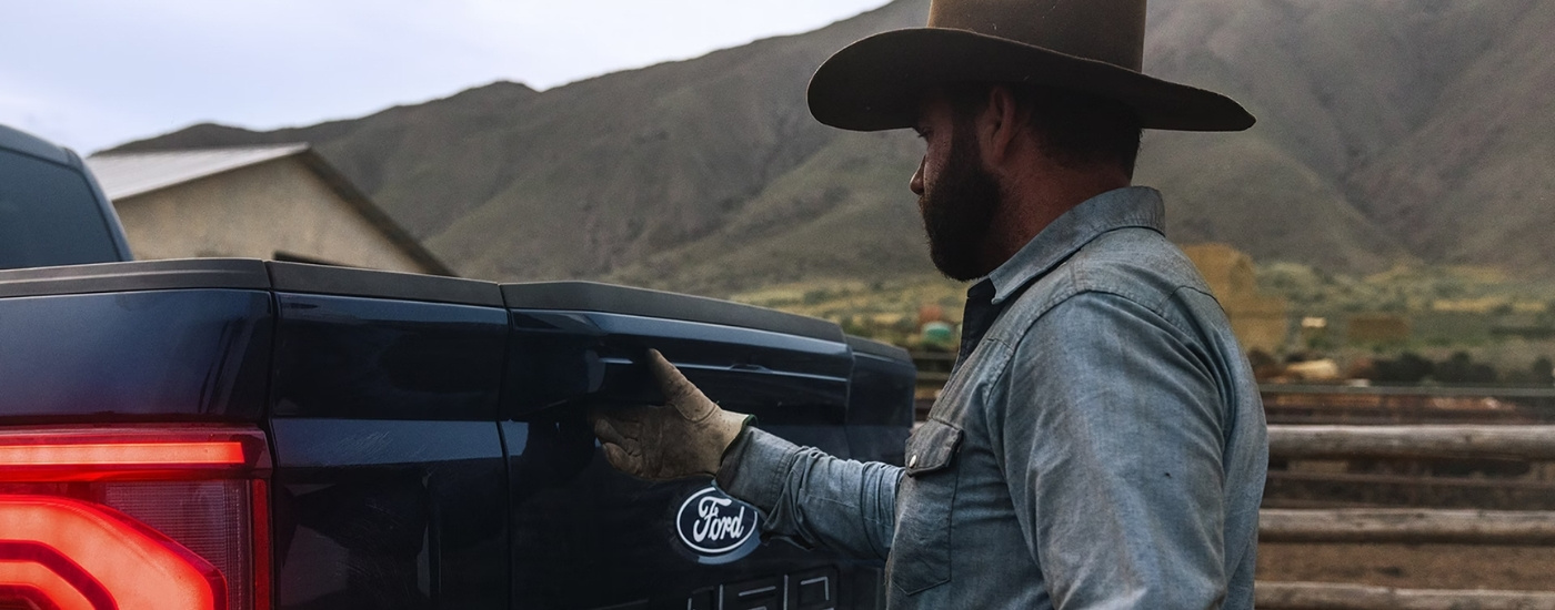 Person opening the tailgate on a blue 2026 Ford F-150 King Ranch