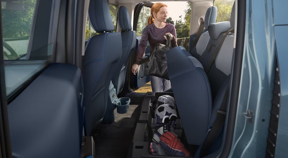 Woman using the under storage seats in a 2026 Ford Maverick