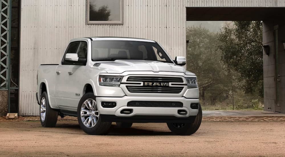 A white 2020 Ram 1500 is shown parked in front of a barn.