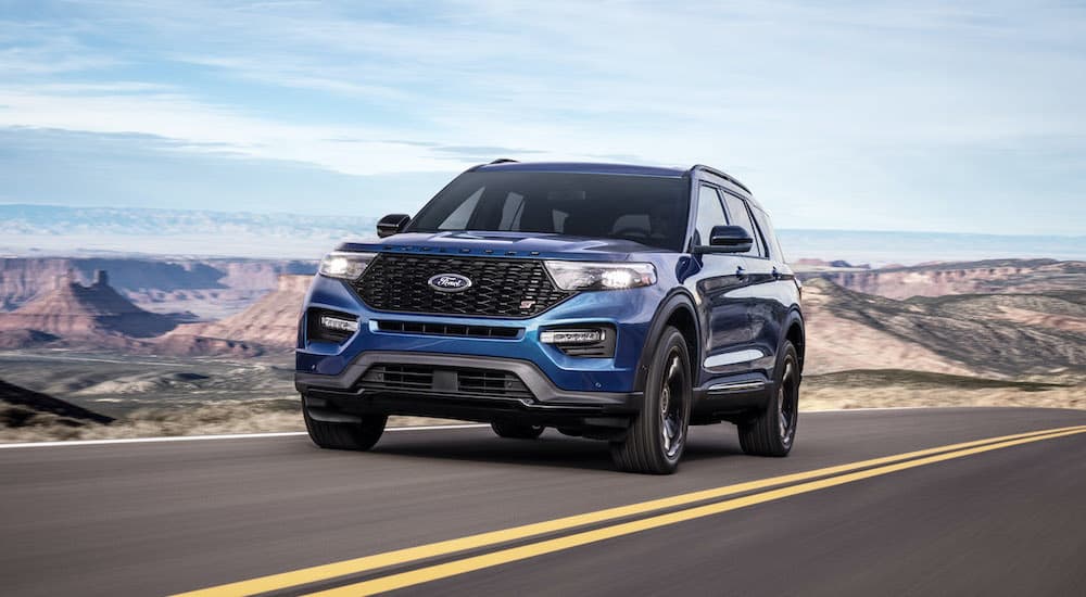 A blue 2020 Ford Explorer St is shown from the front driving on an open road.