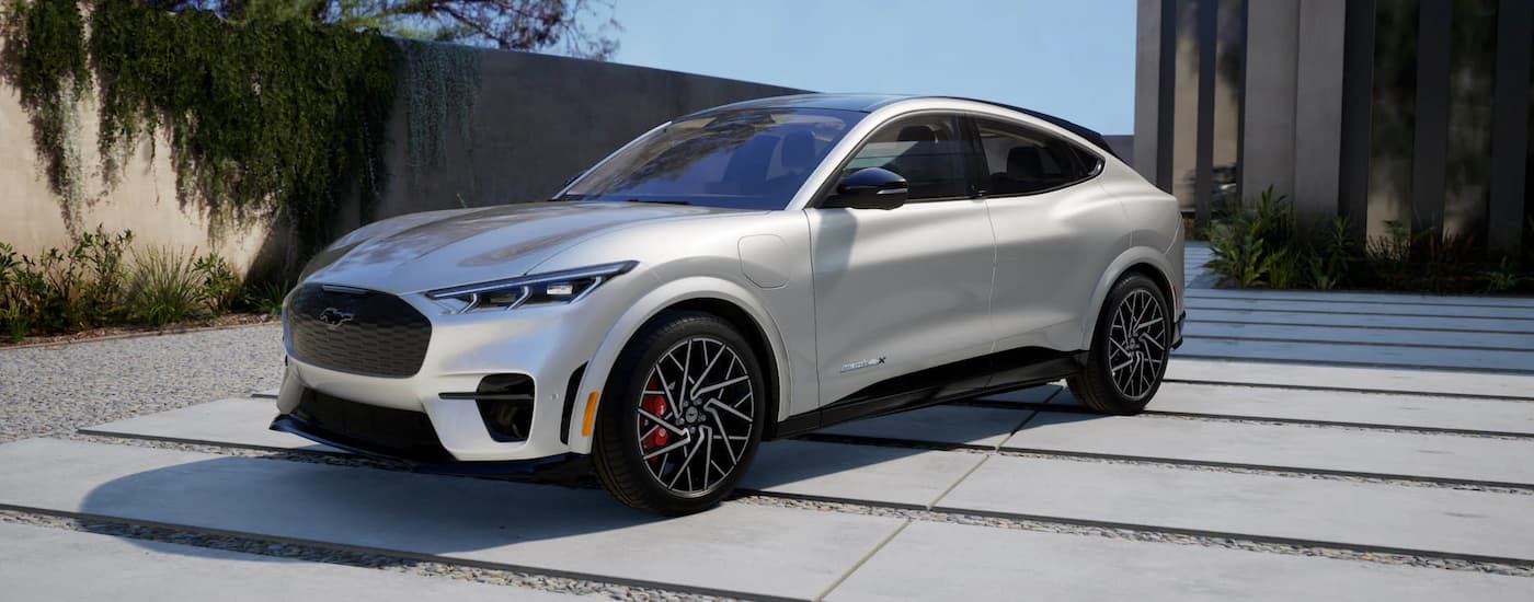 A silver EV for sale near you, a 2023 Ford Mustang, is shown in a driveway.