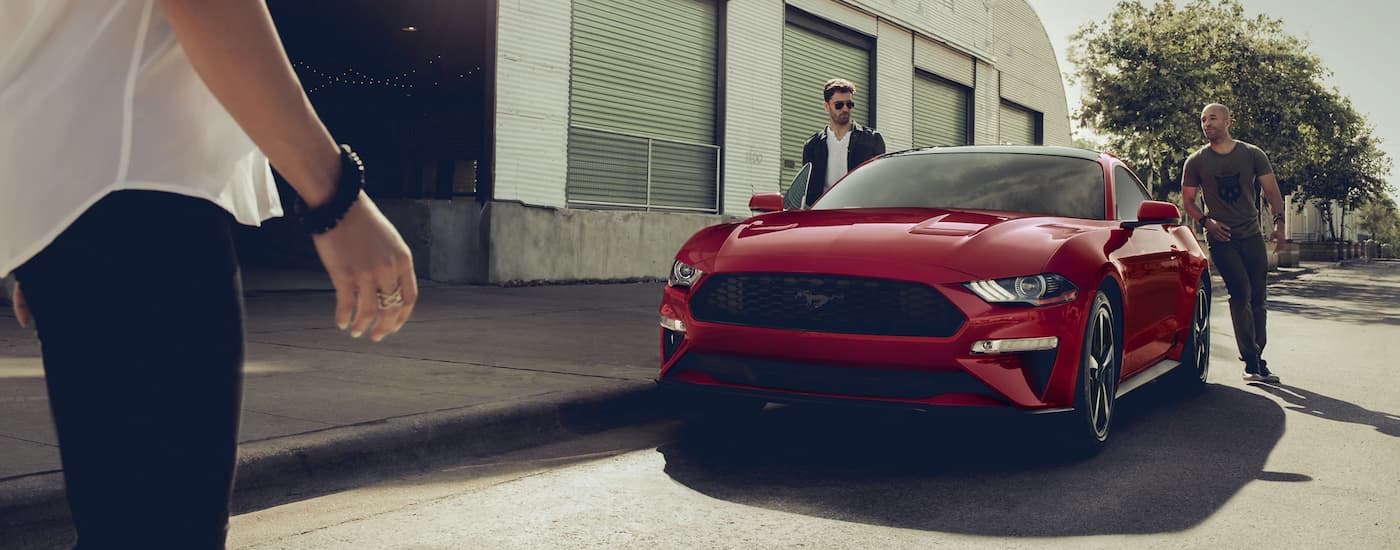 A red 2021 Ford Mustang GT parked in front of a garage after leaving a Folsom Ford dealership.