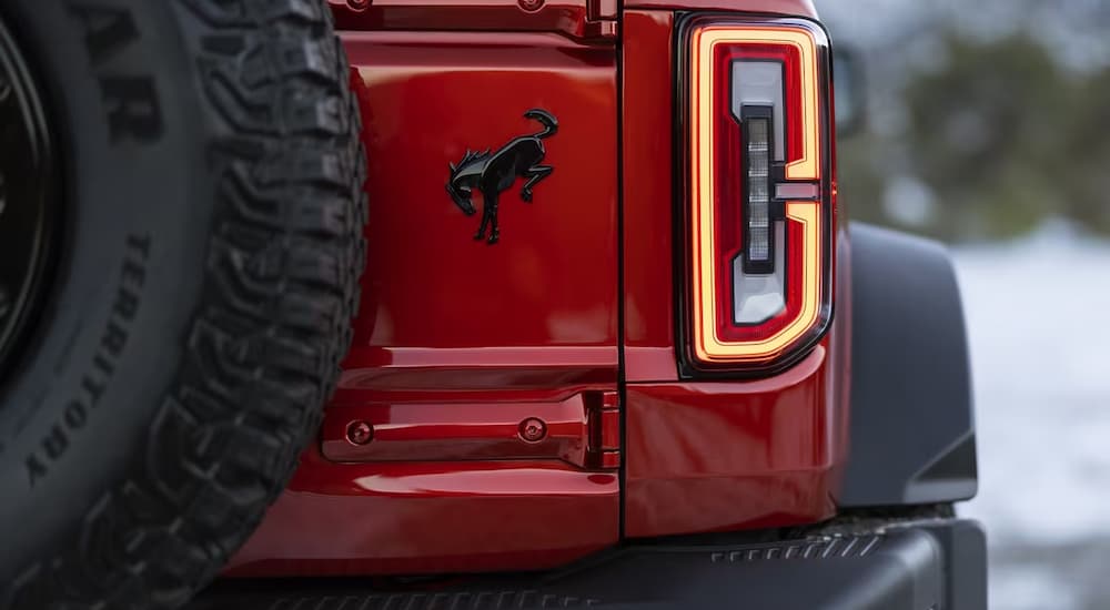 A close up of the rear brakelight and bumper on a red 2024 Ford Bronco Wildtrak is shown.