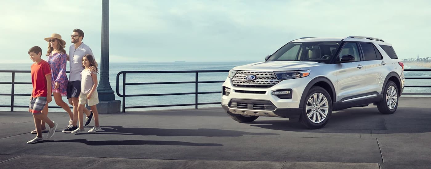 A white 2023 Ford Explorer Limited Hybrid is shown parked on a pier.