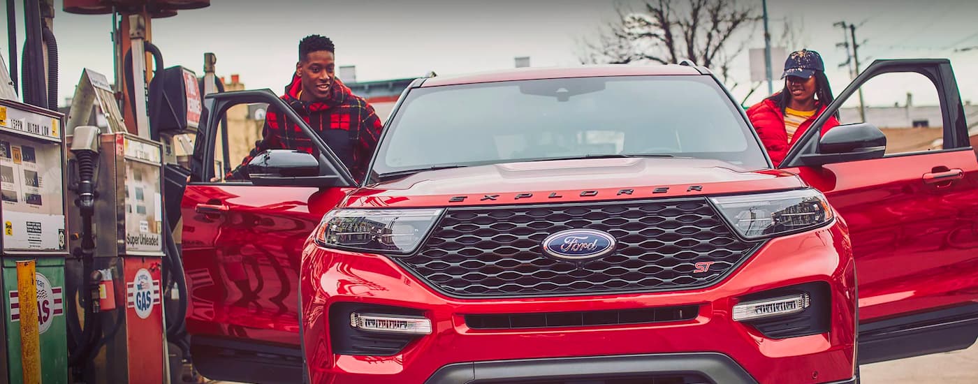 A red 2022 Ford Explorer ST is shown from the front at a gas station.