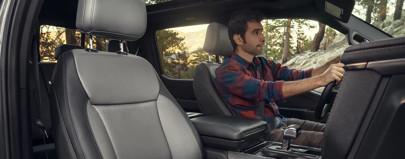 Interior view of a man driving a 2022 Ford F-150 Lightning.