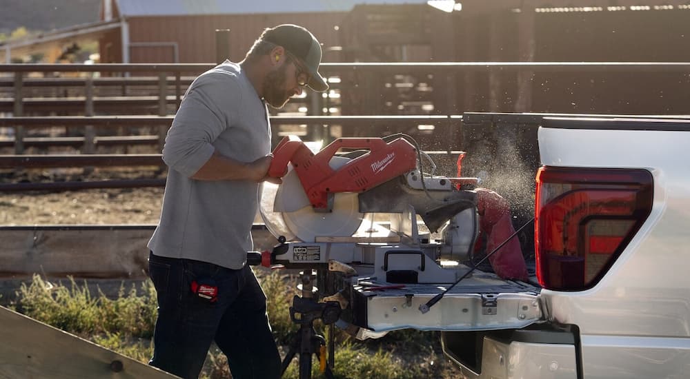 Man using power tools in the bed of a white 2025 Ford F-150