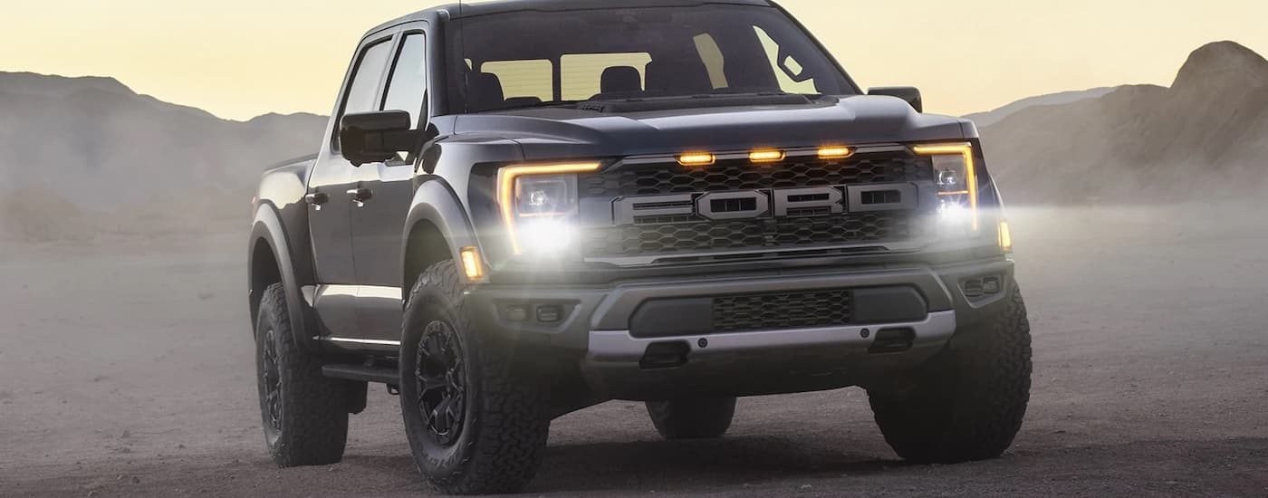 A black 2022 Ford F-150 Raptor is shown parked in a desert.