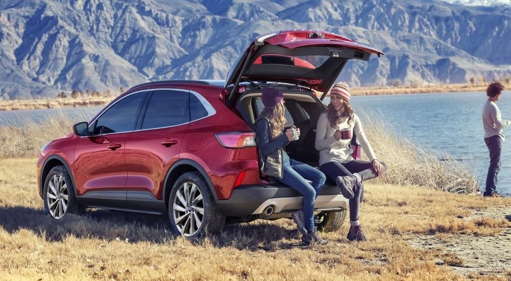 People sitting on the back of a red 2022 Ford Escape