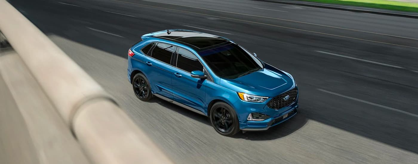 A blue 2020 Ford Edge ST is shown on a highway.