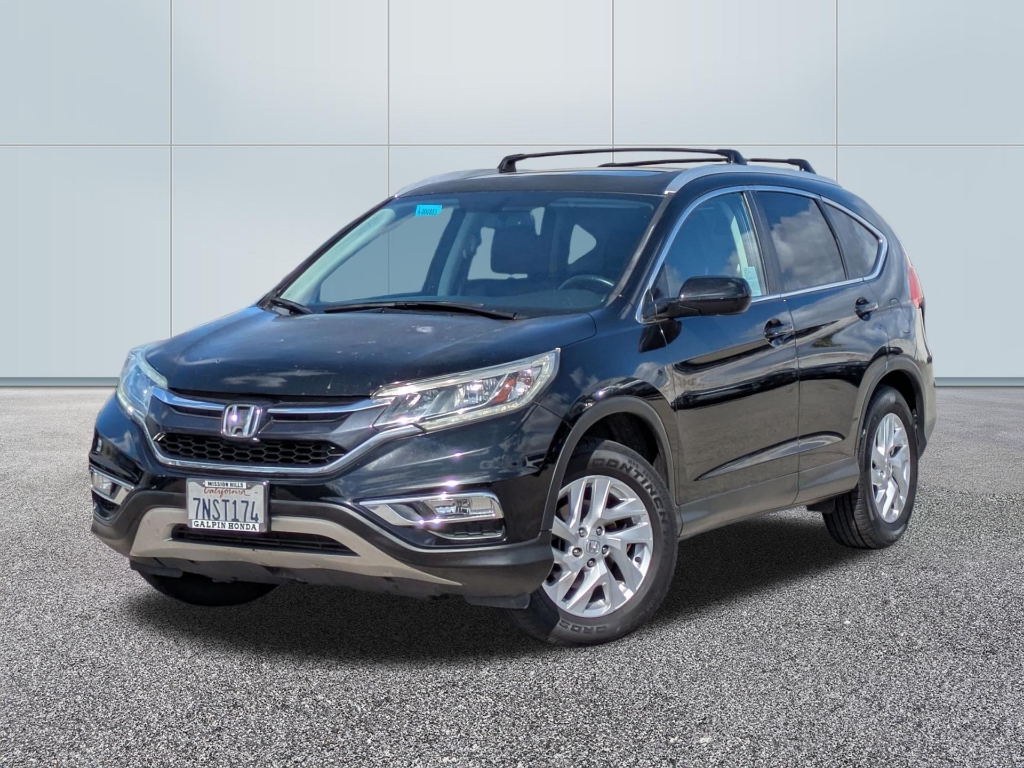 A three-quarter front view of a black Honda CR-V (fourth generation, facelift model circa 2015–2016) parked on a grey gravel-textured surface against a neutral, white paneled backdrop. The vehicle’s key features include: Front Fascia: A chrome-accented grille with the Honda "H" logo, integrated LED daytime running lights, and a silver-colored lower bumper garnish. Roof Gear: Slim black roof rails with crossbars installed. Wheels: Silver multi-spoke alloy wheels fitted with Continental tires. Identification: A California license plate reading "7NST174" with a "Galpin Honda" dealer frame. The car is captured in bright, natural light, showing some minor dust or spotting on the hood, typical of a pre-detailed or used vehicle listing.