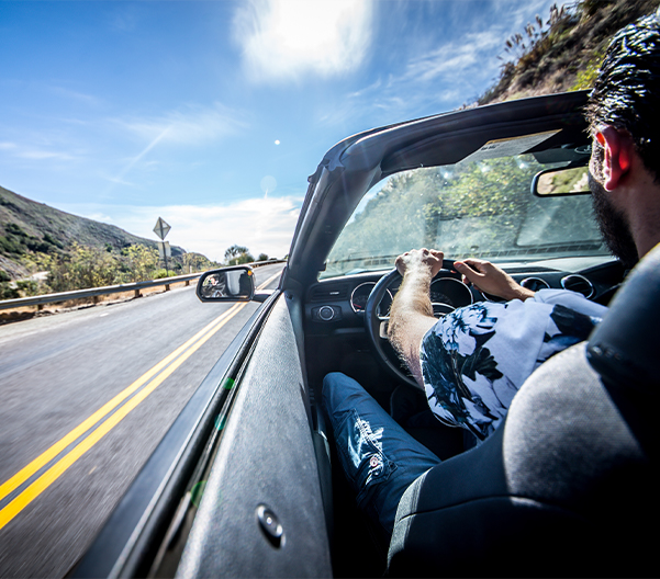 person driving on a coastal highway