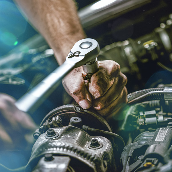 Auto mechanic working on car engine in mechanics garage. Repair service. authentic close-up shot