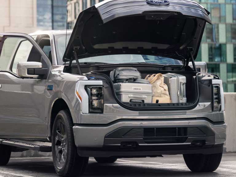 A Ford F-150 Lightning with the Frunk open.