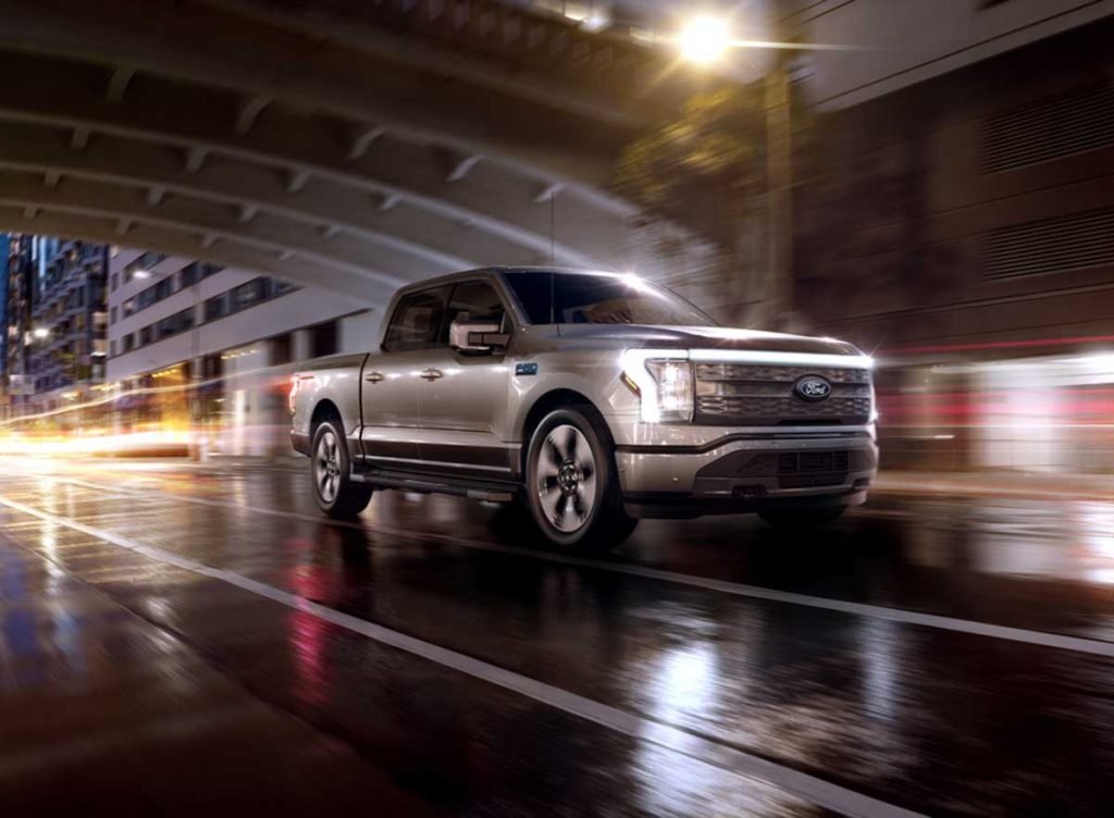 An F-150 Lightning® being driven in the city at night