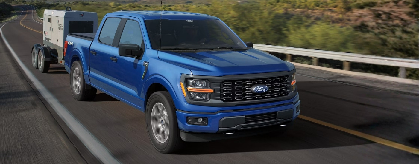 Blue 2025 Ford F-150 STX towing a generator