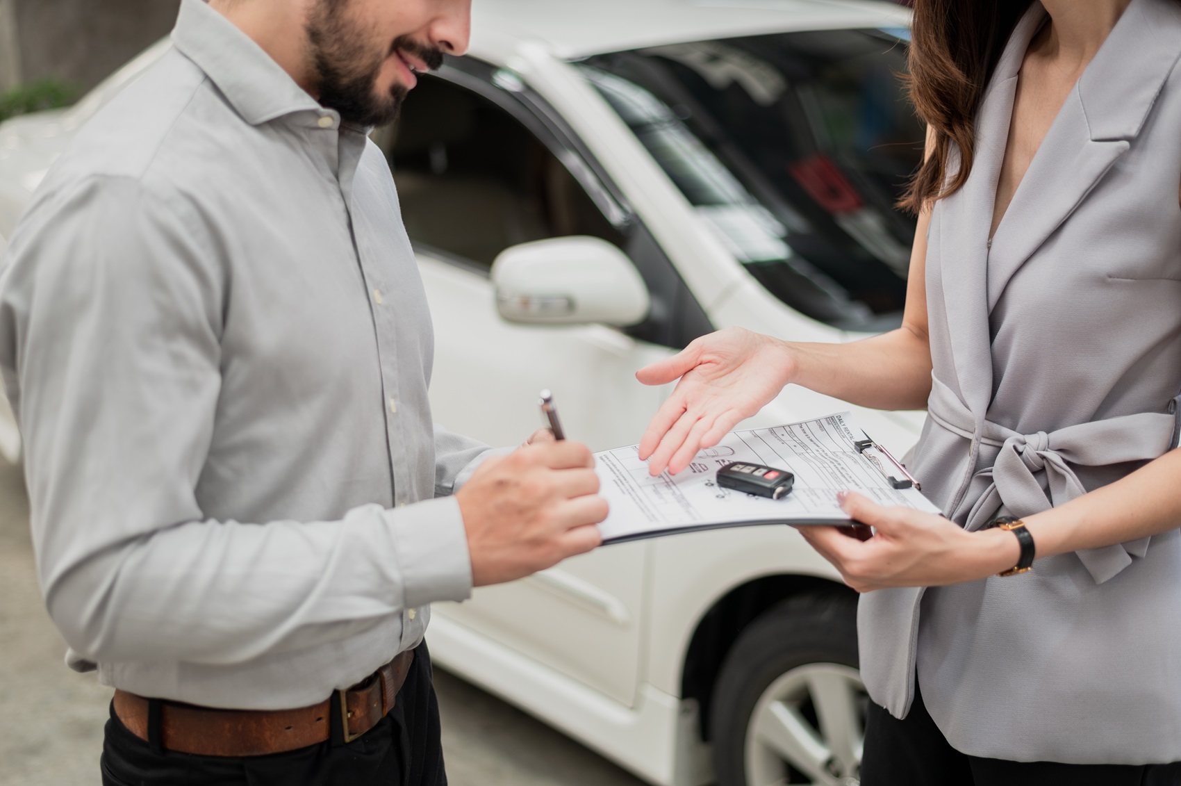 Buyer signing contract in front of a Ford car