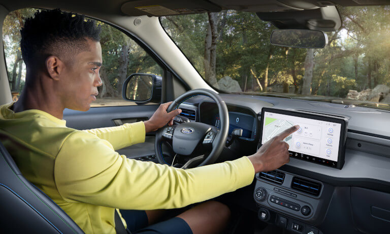 2026 Ford Maverick with driver using infotainment system