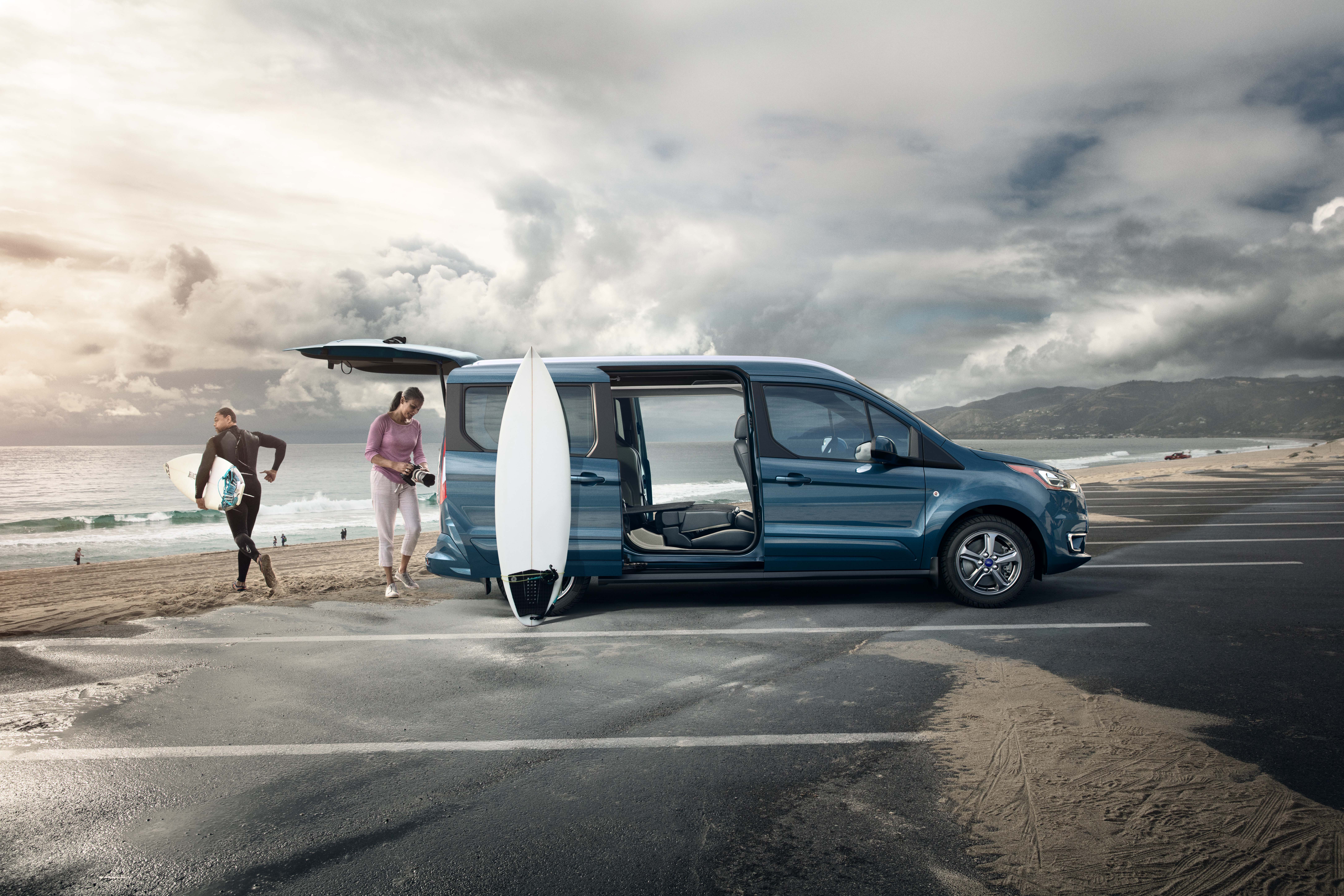 Couple surfing next to parked 2019 Ford Transit Connect