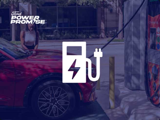 A woman with her red Ford Mustang Mach-E® at a charging station with public charging icon overlaid